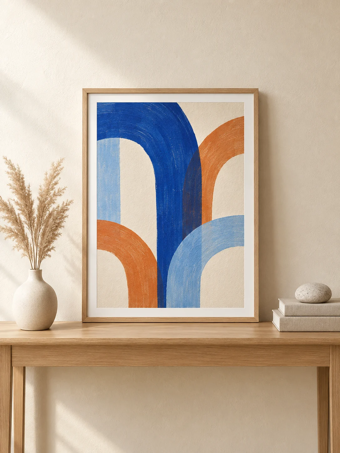 Framed abstract print in blue and orange on a wooden console table